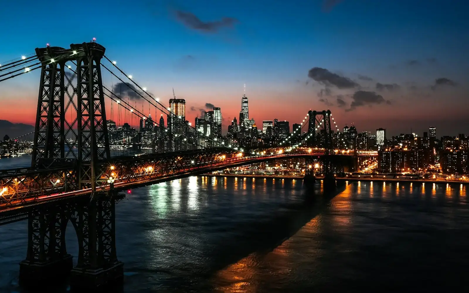 A cable-stayed bridge beside illuminated high-rise buildings